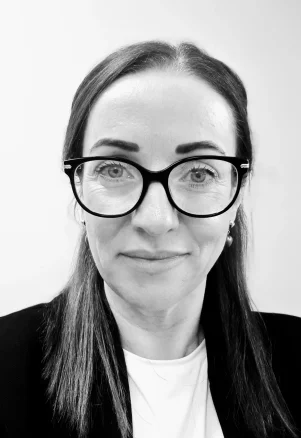 Portrait of Edel, a professional psychotherapist and counsellor, smiling warmly against a neutral background.